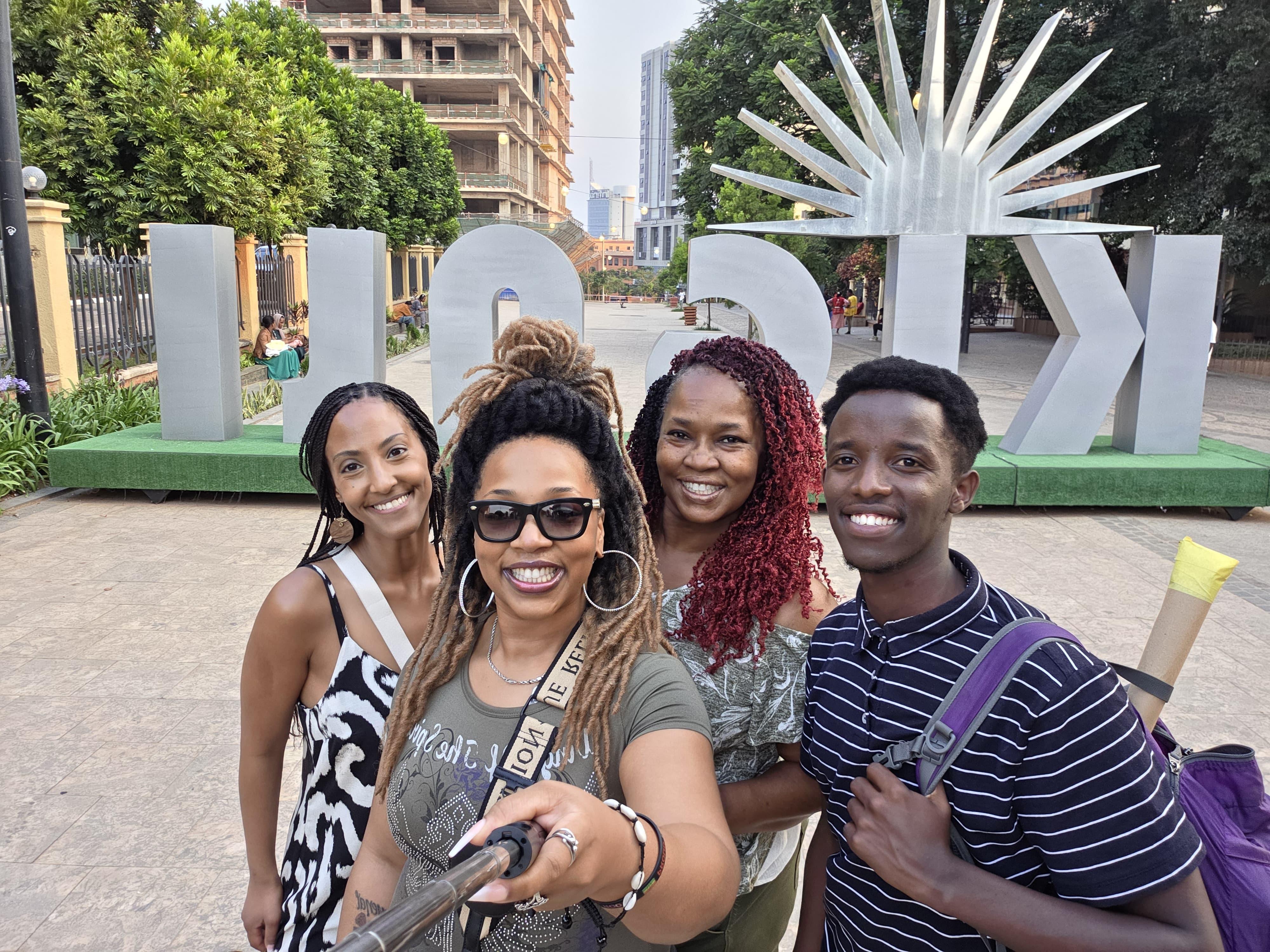 Visitors at the KIGALI sign in the Car Free Zone, downtown Kigali